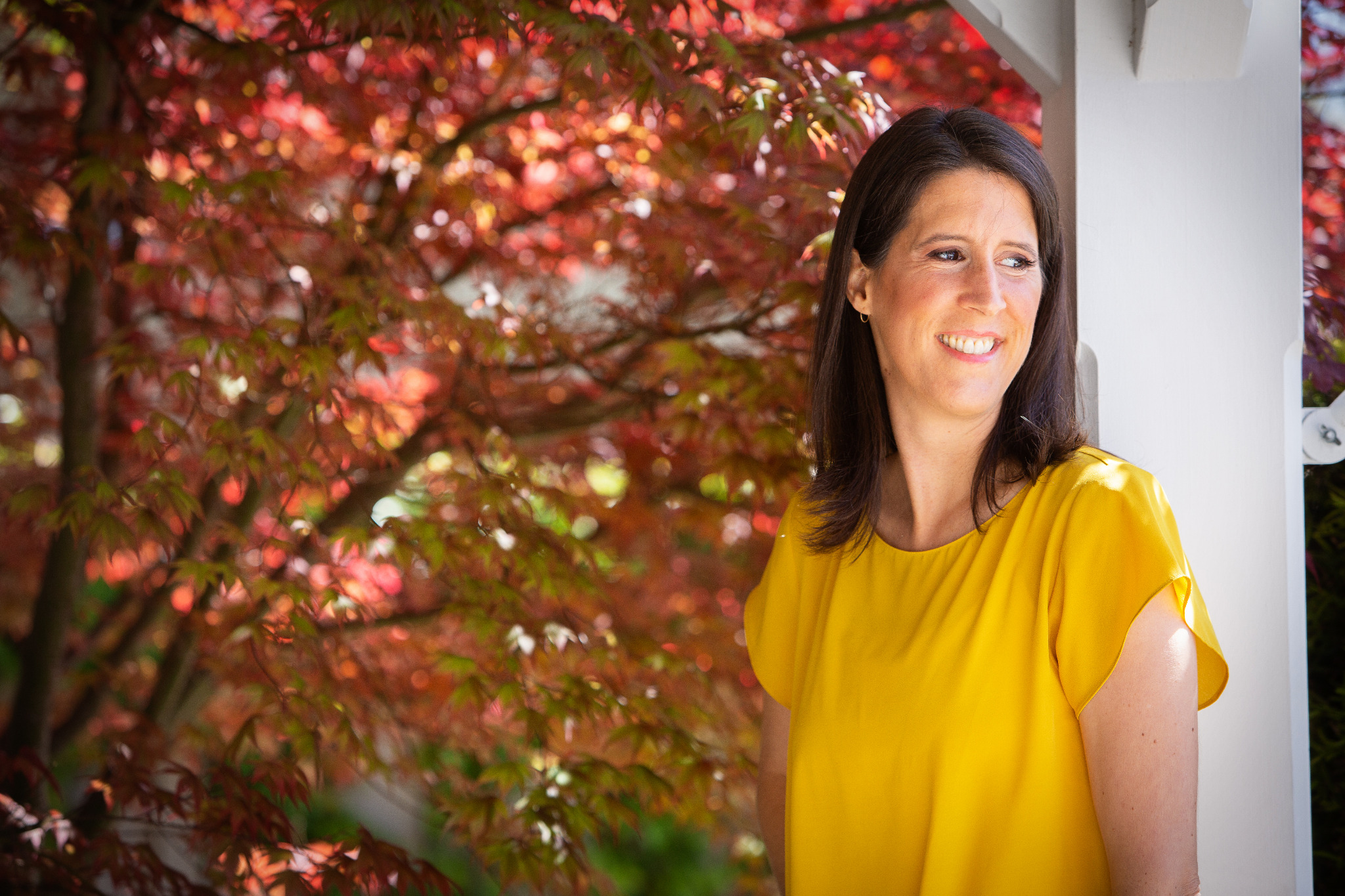 Katie outdoors in a yellow top.