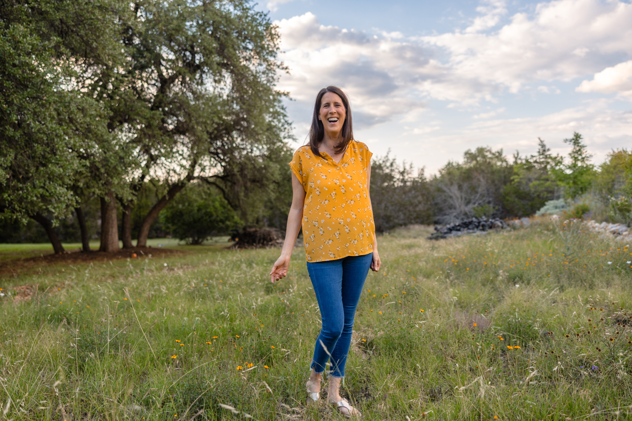 Katie walking through a grassy field.