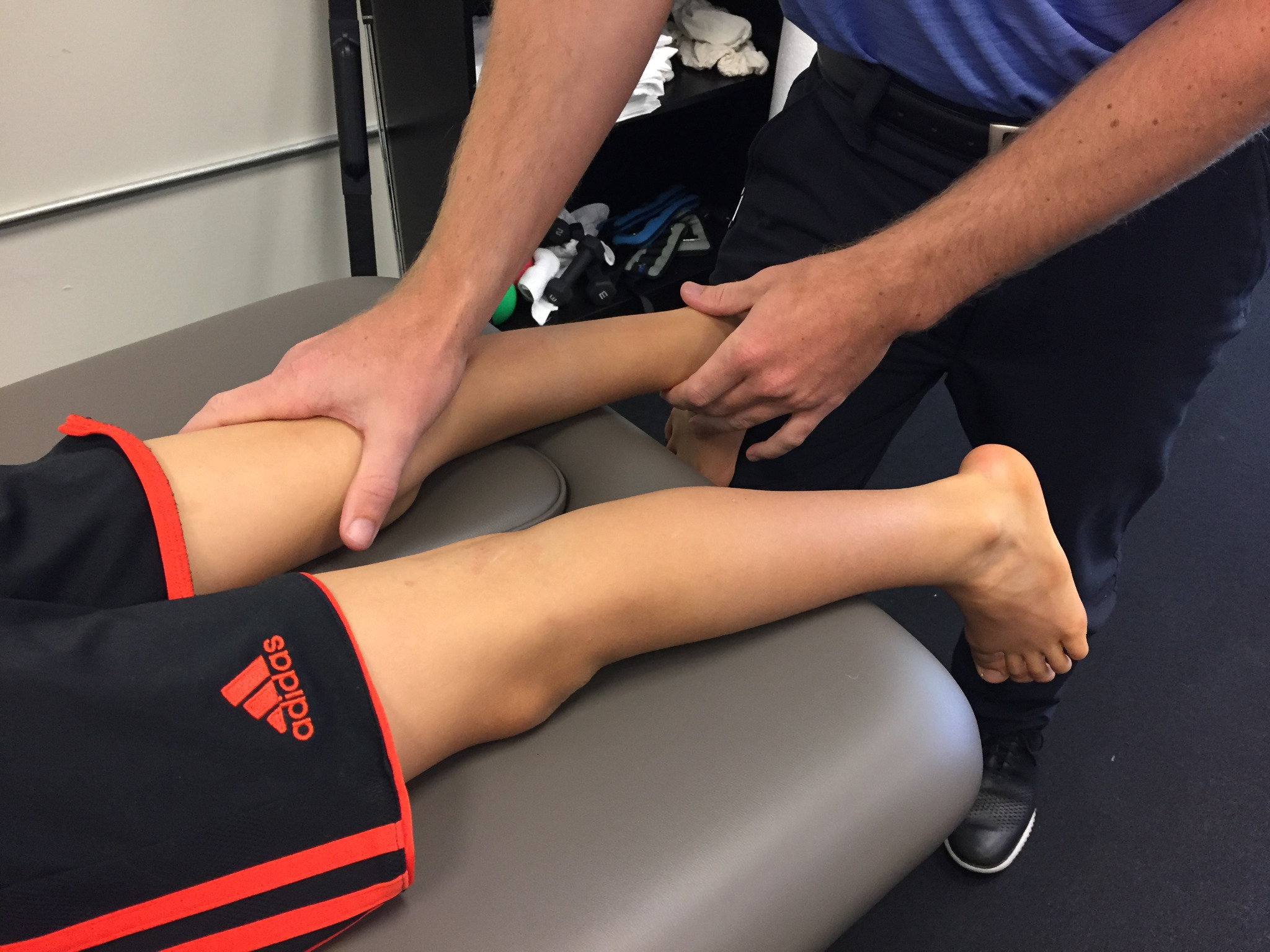 Physical therapist working on a child's feet and lower legs.