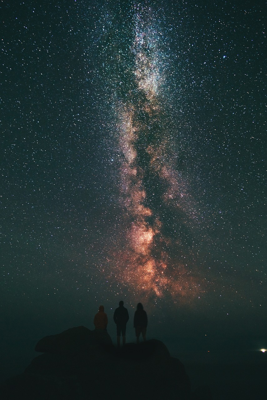 People beneath the Milky Way night sky.